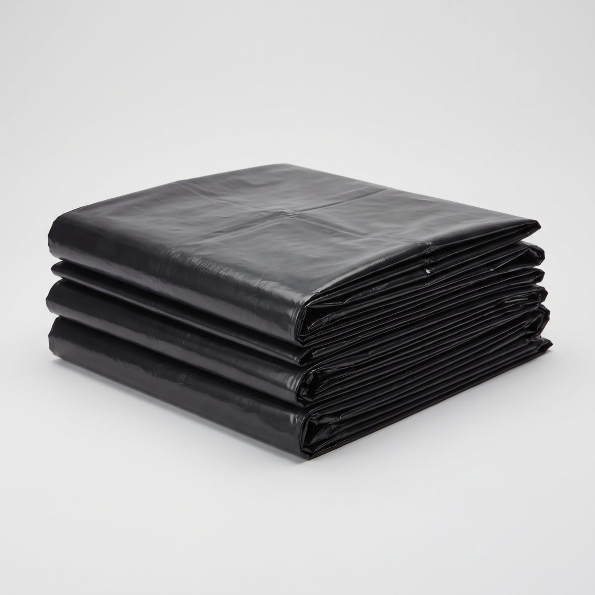 Stack of flat-folded black commercial garbage bags
